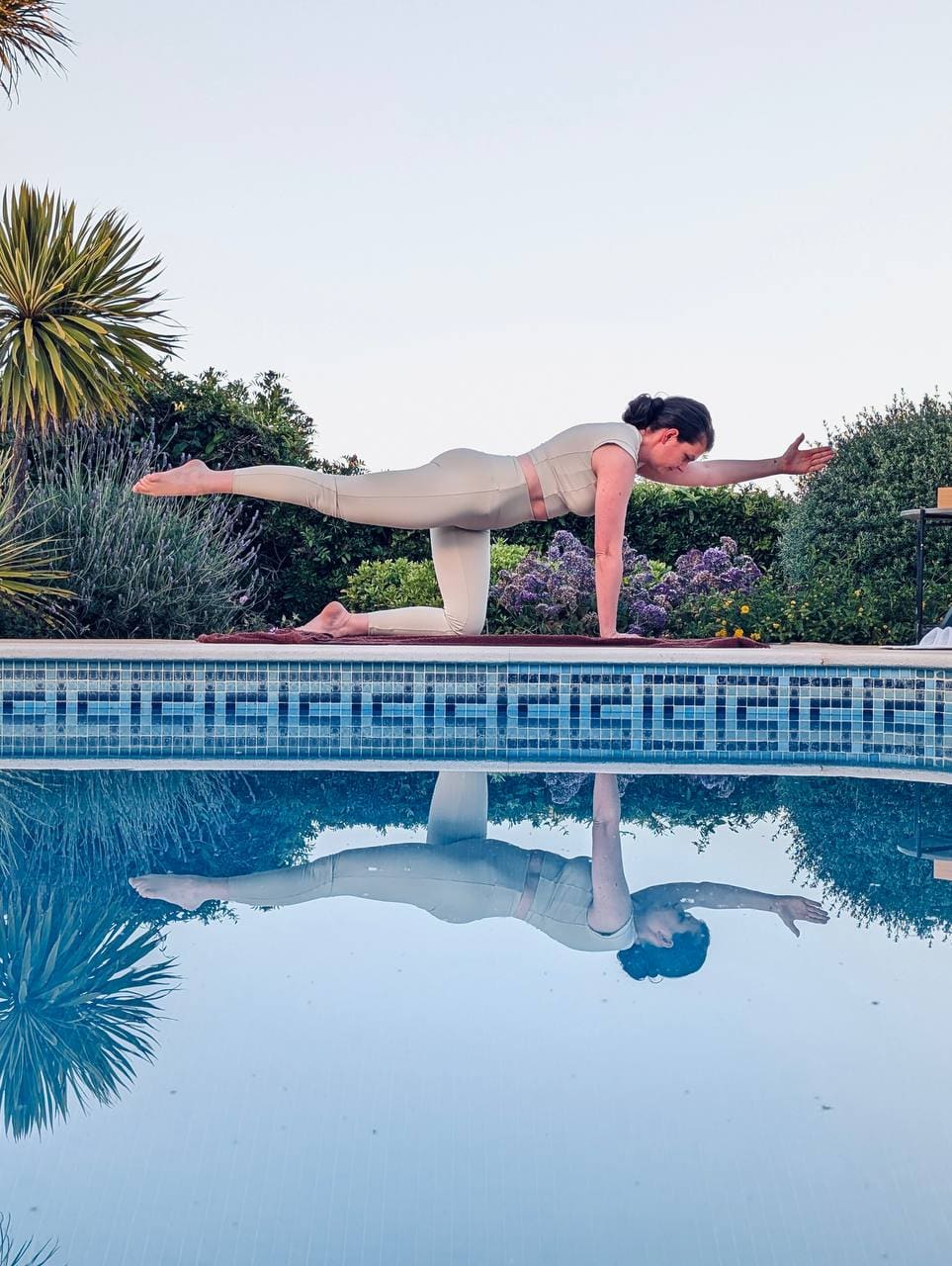 Eszter Nagy in a tabletop Pilates pose by the pool