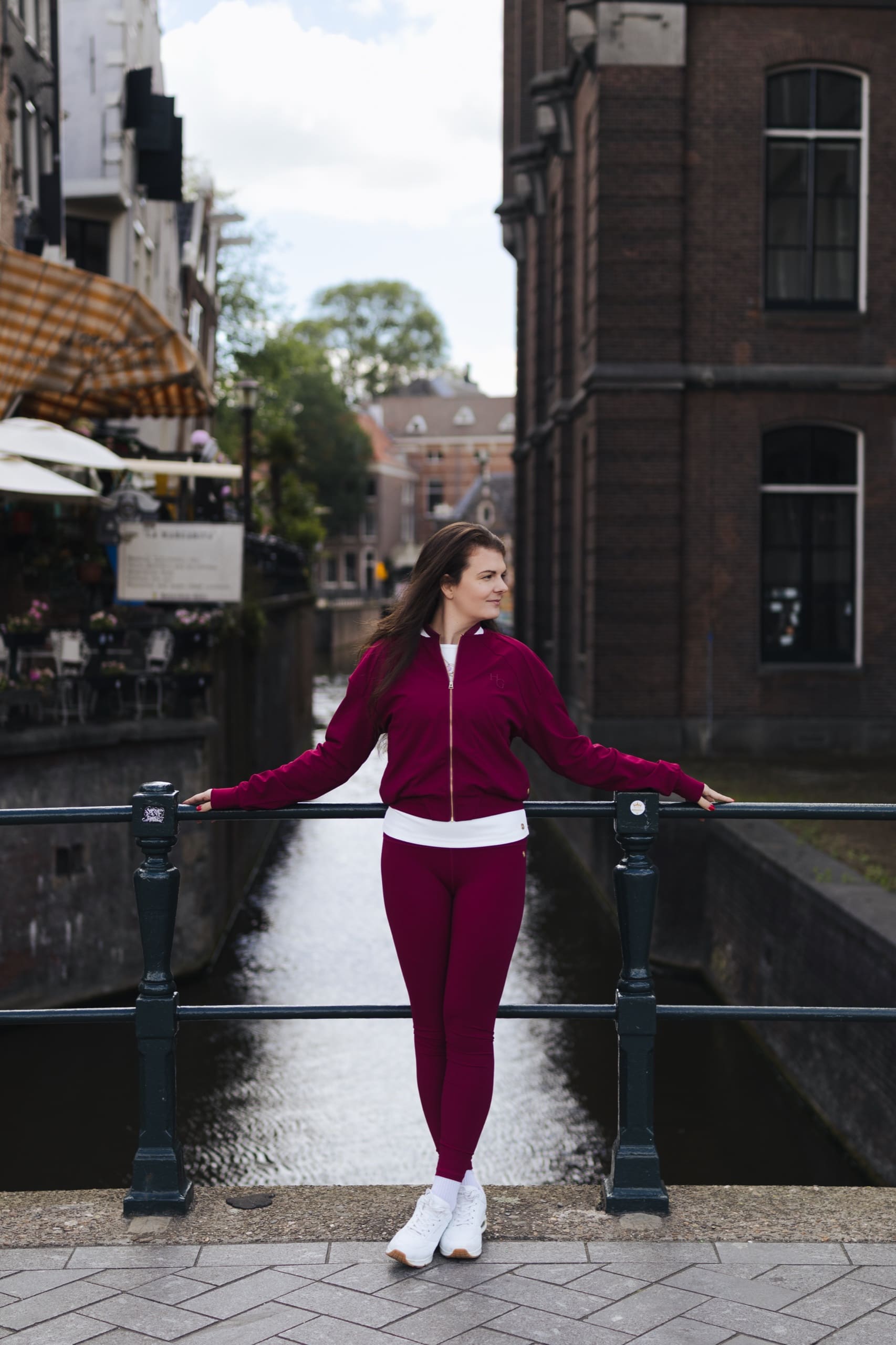 Standing relaxed against a canal-bridge railing