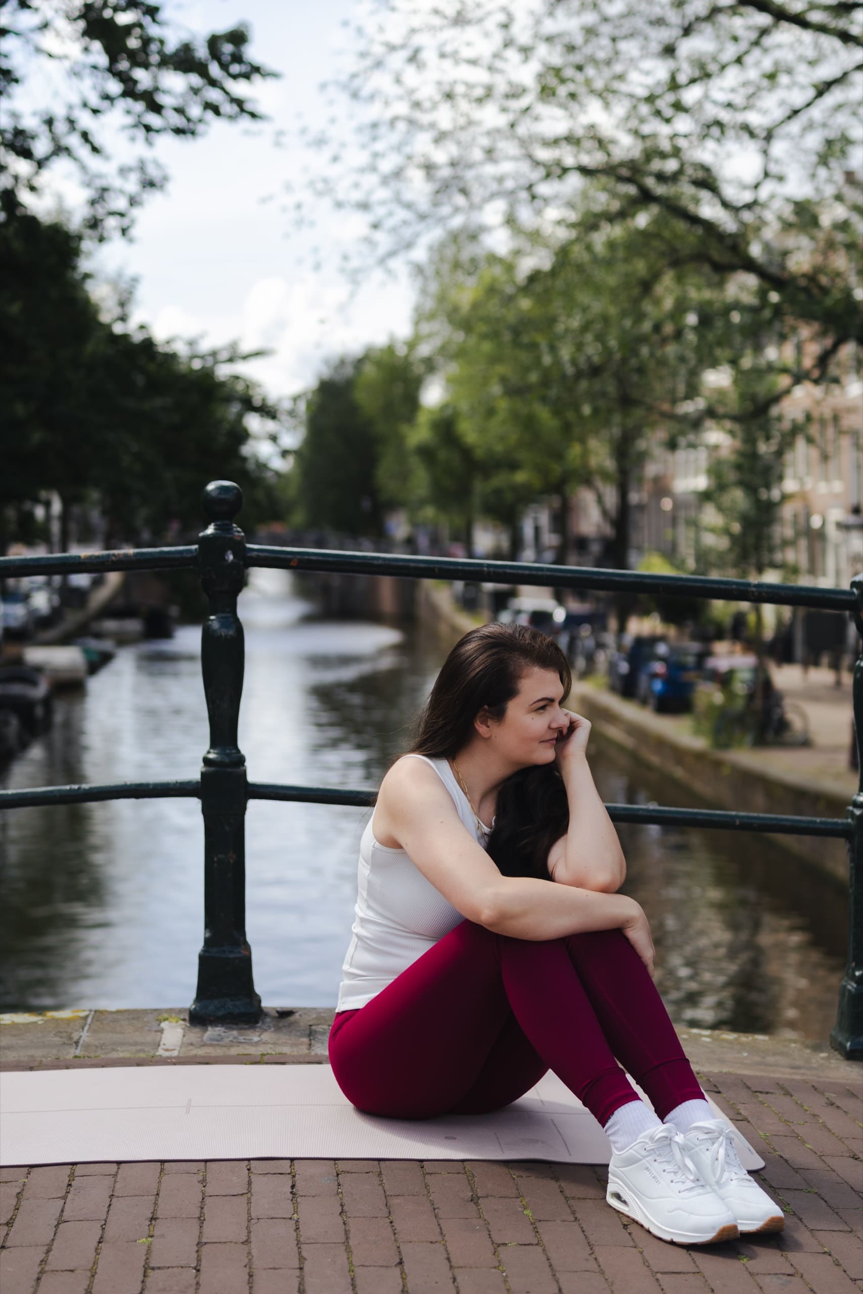Sitting on a mat by the canal, resting after practice
